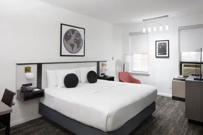 a bedroom with a large white bed and a desk at Ramada by Wyndham Jersey City in Jersey City