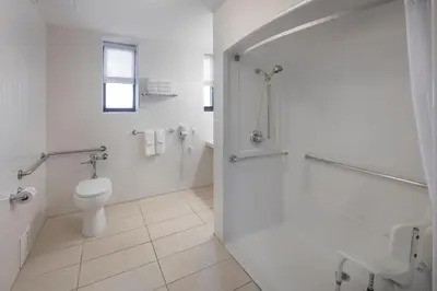a white bathroom with a toilet and a shower at Ramada by Wyndham Jersey City in Jersey City