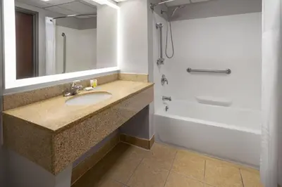 a bathroom with a sink and a tub and a shower at Baymont by Wyndham Westampton in Westampton Township