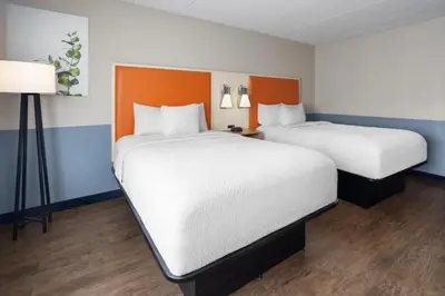 two beds in a room with orange and blue walls at Baymont by Wyndham Westampton in Westampton Township