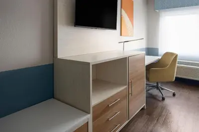 an office cubicle with a desk and a tv on the wall at Baymont by Wyndham Westampton in Westampton Township