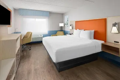 a hotel room with a large bed and a desk at Baymont by Wyndham Westampton in Westampton Township