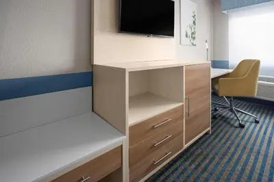 a room with a desk with a tv on top at Baymont by Wyndham Westampton in Westampton Township