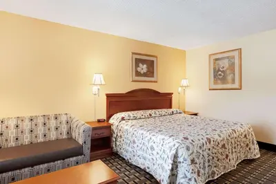a hotel room with a bed and a chair at Knights Inn Mount Laurel in Mount Laurel