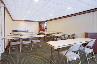 a classroom with tables and chairs and a white wall at Knights Inn Mount Laurel in Mount Laurel