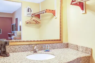 a bathroom with a sink and a large mirror at Knights Inn Mount Laurel in Mount Laurel