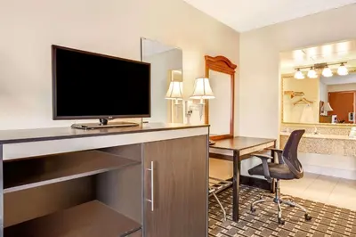 a hotel room with a desk with a television and a room with a deskicter at Knights Inn Mount Laurel in Mount Laurel