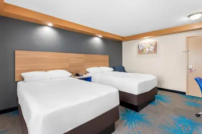 a hotel room with two beds and a desk at Econo Lodge Woodbridge in Iselin