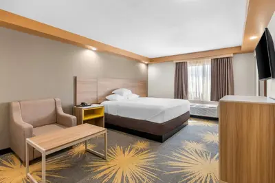 a hotel room with a bed and a chair at Econo Lodge Woodbridge in Iselin