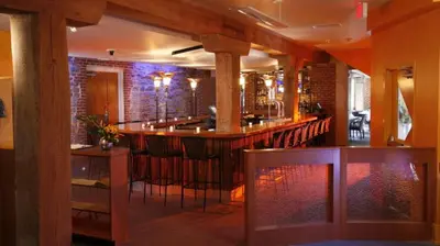 a kitchen with a bar with stools at Lancaster Arts Hotel in Lancaster