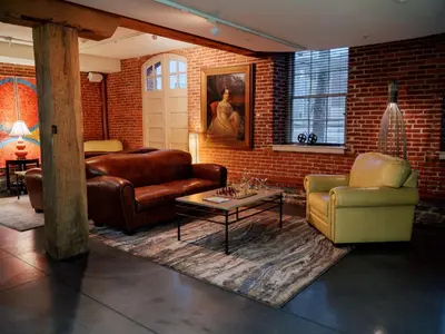 a living room with leather furniture and a brick wall at Lancaster Arts Hotel in Lancaster