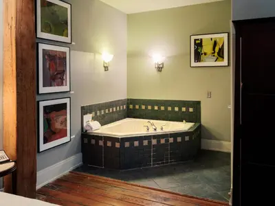 a bathroom with a tub and paintings on the wall at Lancaster Arts Hotel in Lancaster