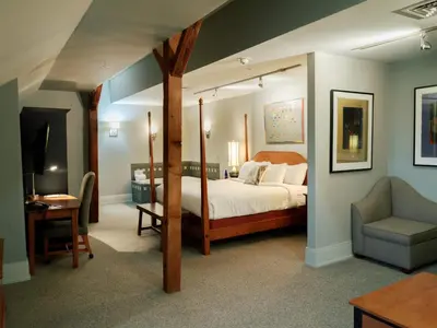 a bedroom with a canopy bed and a chair at Lancaster Arts Hotel in Lancaster