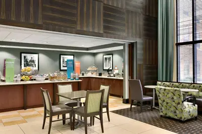 a restaurant with a table and chairs and a bar at Hampton Inn & Suites Mahwah in Mahwah