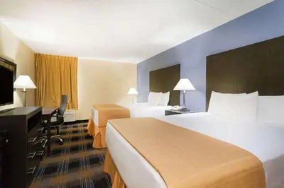 a hotel room with two beds and a television at Days Inn by Wyndham Wilkes Barre in Wilkes-Barre