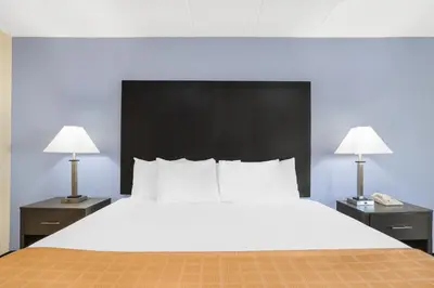 a large bed in a hotel room with two lamps at Days Inn by Wyndham Wilkes Barre in Wilkes-Barre
