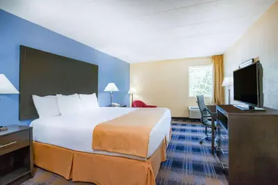 a hotel room with a bed and a desk and a television at Days Inn by Wyndham Wilkes Barre in Wilkes-Barre