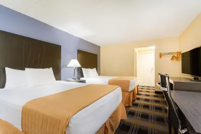 a hotel room with two beds and a flat screen tv at Days Inn by Wyndham Wilkes Barre in Wilkes-Barre