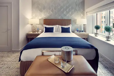 a hotel room with a large bed and two tables at Artezen Hotel in New York