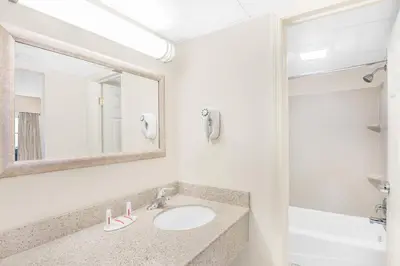 a bathroom with a sink and a mirror at Days Inn by Wyndham Springfield/Phil.Intl Airport in Springfield
