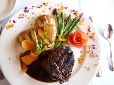 a plate of food with meat and vegetables on a table at Days Inn by Wyndham Springfield/Phil.Intl Airport in Springfield