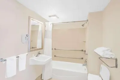 a white bathroom with a sink and a toilet at Days Inn by Wyndham Springfield/Phil.Intl Airport in Springfield