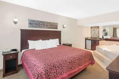 a hotel room with a bed and a bathroom at Days Inn by Wyndham Springfield/Phil.Intl Airport in Springfield