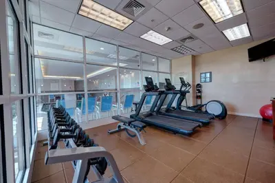 a gym with rows of treadmills and elliptical machines at Hilton Garden Inn Hamilton in Bordentown