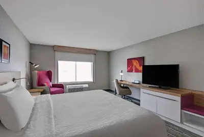 a hotel room with a bed and a flat screen tv at Hilton Garden Inn Hamilton in Bordentown
