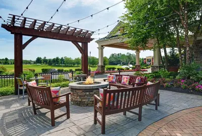 a patio with two benches and a fire pit at Hilton Garden Inn Hamilton in Bordentown