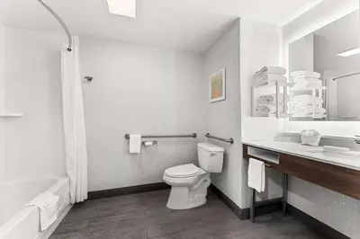 a bathroom with a toilet and a sink and a tub at Hampton Inn Stroudsburg Poconos in Stroudsburg