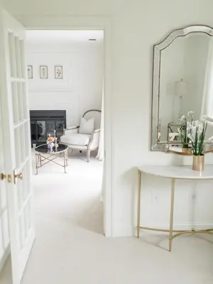 a living room with a mirror and a chair at Fairville Inn in Chadds Ford