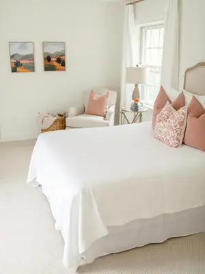 a bedroom with a large white bed with pink pillows at Fairville Inn in Chadds Ford