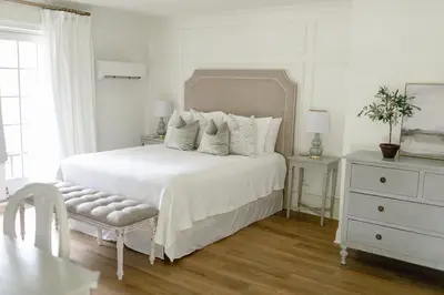 a white bedroom with a white bed and a dresser at Fairville Inn in Chadds Ford