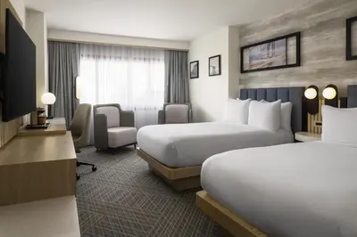 a hotel room with two beds and a desk at DoubleTree by Hilton Fort Lee/George Washington Bridge in Fort Lee