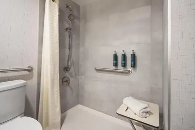 a bathroom with a shower with a toilet and a sink at DoubleTree by Hilton Fort Lee/George Washington Bridge in Fort Lee
