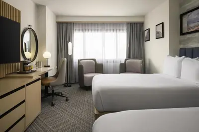 a hotel room with two beds and a desk at DoubleTree by Hilton Fort Lee/George Washington Bridge in Fort Lee