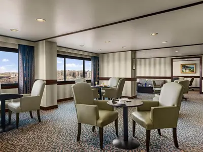 a waiting room with tables and chairs and windows at DoubleTree by Hilton Fort Lee/George Washington Bridge in Fort Lee