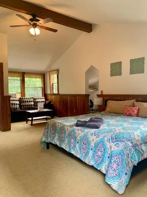 a bedroom with a bed and a ceiling fan at Magnolia Streamside Resort in Canadensis