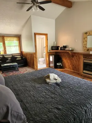 a bedroom with a large bed with a hat on it at Magnolia Streamside Resort in Canadensis