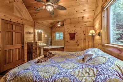 a bedroom with a bed in a log cabin at Magnolia Streamside Resort in Canadensis