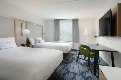 a hotel room with two beds and a desk at Fairfield Inn & Suites by Marriott Pottstown Limerick in Pottstown