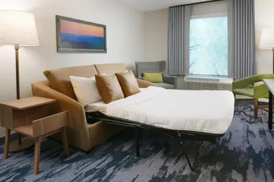 a hotel room with a bed and a couch at Fairfield Inn & Suites by Marriott Pottstown Limerick in Pottstown
