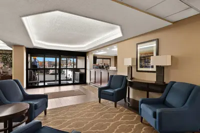 a waiting room with blue chairs and a table and windows at Comfort Inn Bordentown near NJ Turnpike in Bordentown