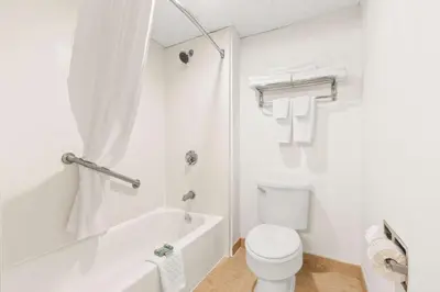 a white bathroom with a toilet and a bath tub at Best Western Hazlet Inn in Hazlet