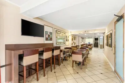 a restaurant with a bar with chairs and a flat screen tv at Best Western Hazlet Inn in Hazlet