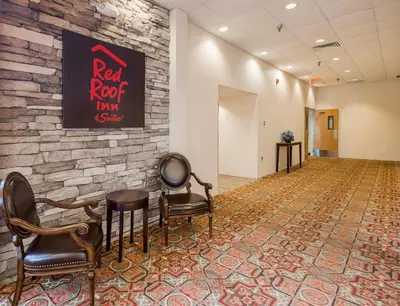a waiting room with chairs and a stone wall at Red Roof Inn & Suites Mt Holly - McGuire AFB in Westampton Township