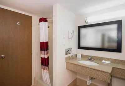 a bathroom with a sink and a flat screen tv at Red Roof Inn & Suites Mt Holly - McGuire AFB in Westampton Township