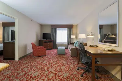 a hotel room with a desk and a bedroom at Hilton Garden Inn Nanuet in Nanuet