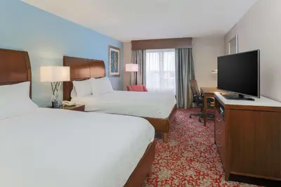 a hotel room with two beds and a flat screen tv at Hilton Garden Inn Nanuet in Nanuet